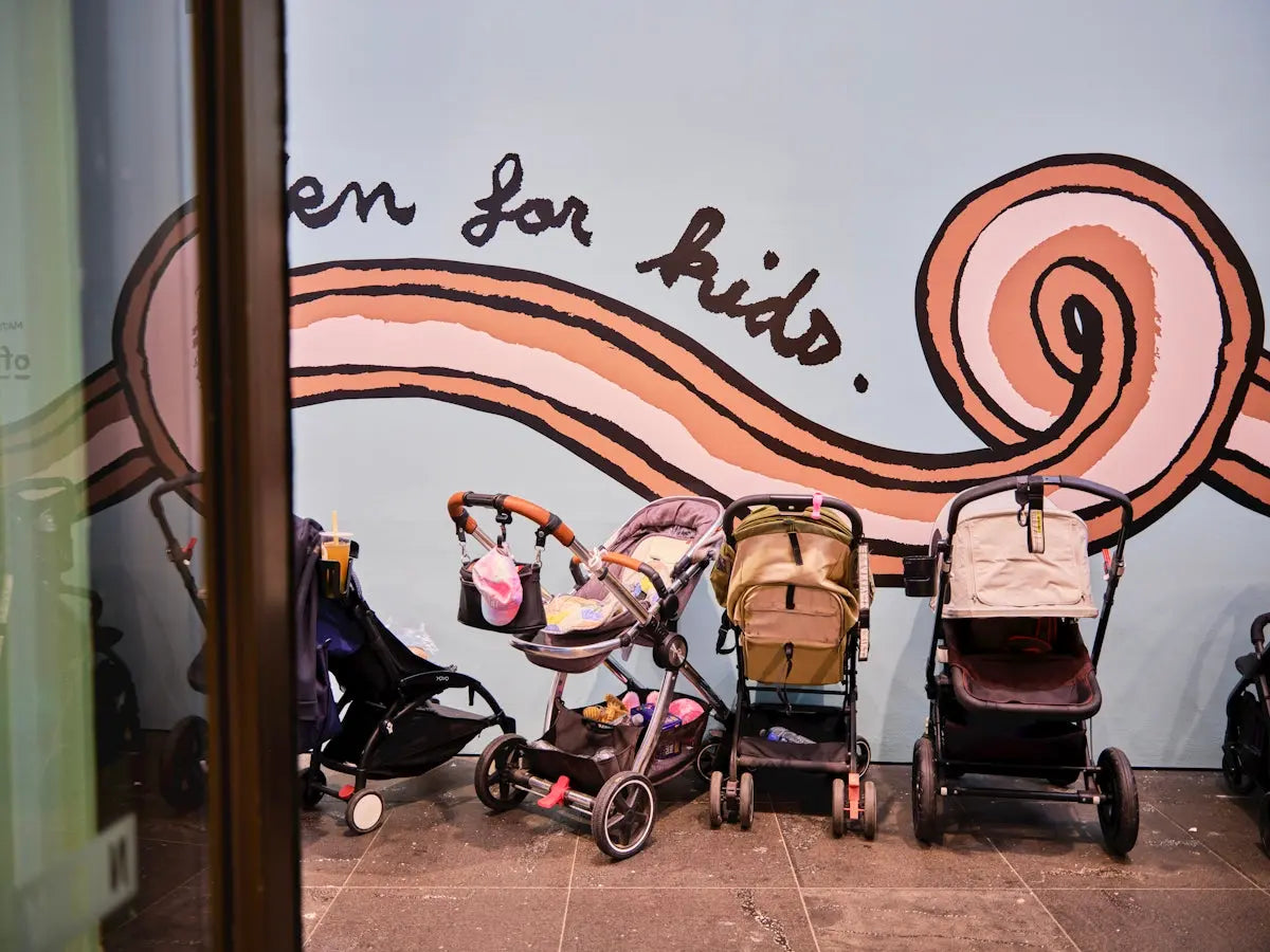 A group of baby strollers sitting in front of a mural