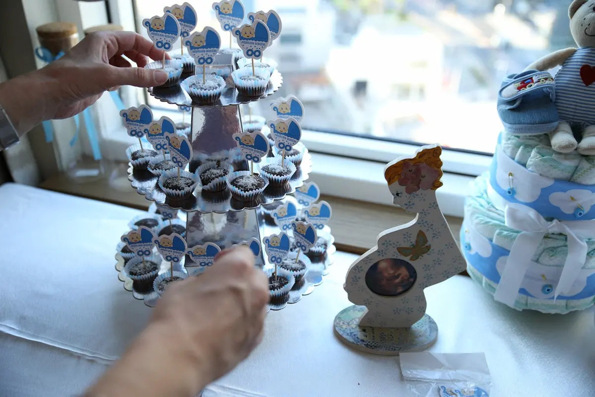 Cupcakes arranged on a tiered stand with baby shower decorations.