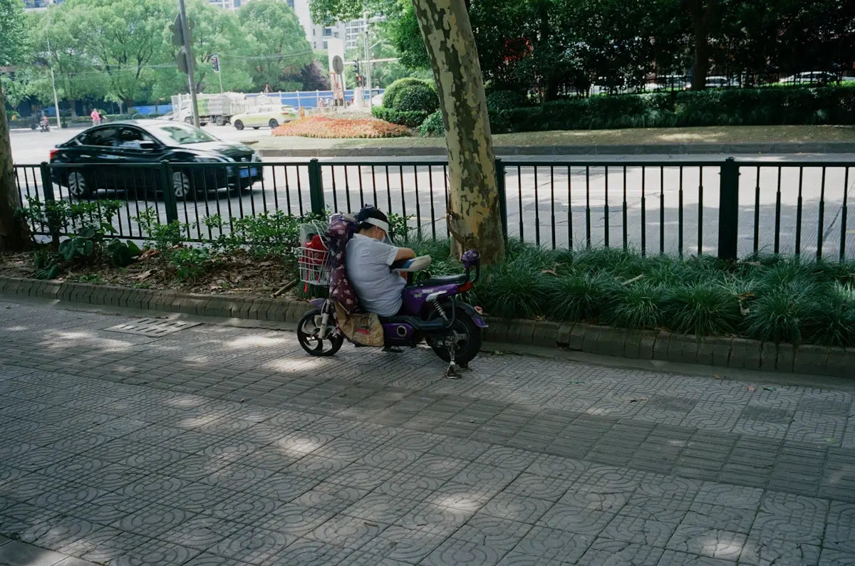 A person pushing a stroller down a sidewalk
